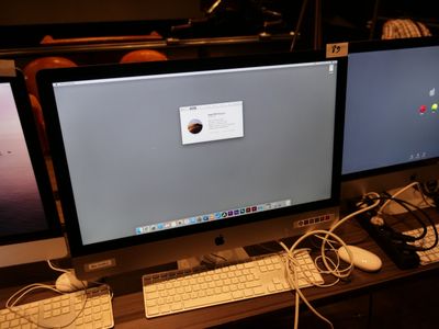 deux écrans d'ordinateur posés sur un bureau avec un clavier et une souris