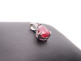 a close up of a red stone pendant on top of a black purse