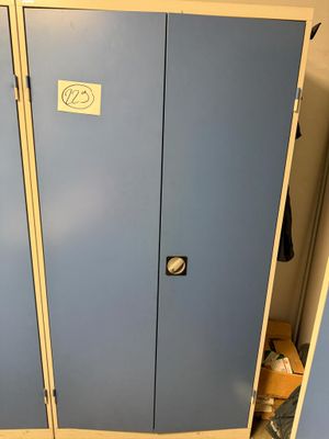 deux casiers bleus dans une pièce où il y a une pancarte sur la porte