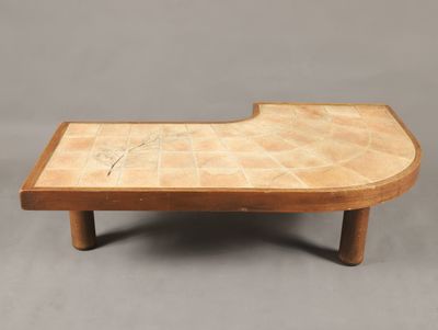 une table basse en bois avec un plateau en carrelage sur fond gris