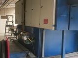a large blue machine in a building with a red hose
