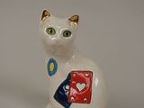 a white cat with green eyes sitting on a white surface
