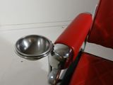 a red chair with a silver bowl on it