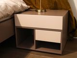 an image of a nightstand with a lamp on top of it