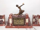 a statue of a woman holding a ball on top of a clock