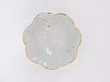 a white plate with a brown rim sitting on a table