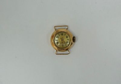 a small gold watch on a white surface