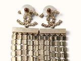 pair of gold tone earrings with pearls and chains on a white background