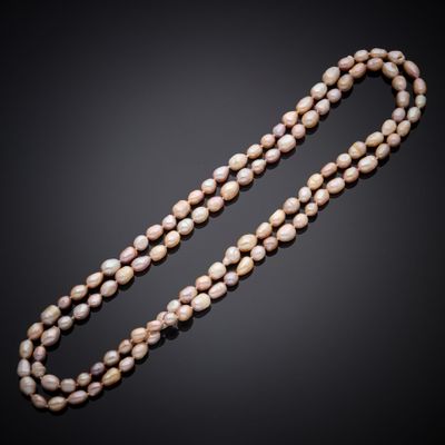 un long collier de perles muni d'un fermoir, sur fond noir