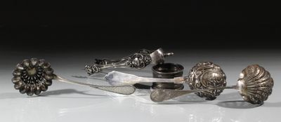 Plusieurs objets en argent sont posés sur une surface blanche
