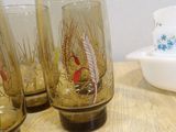 four glasses sitting on a table with a bowl in the background