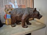 a statue of a bear and a teddy bear on a shelf