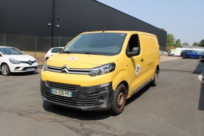 une camionnette jaune garée sur un parking à côté d'autres voitures