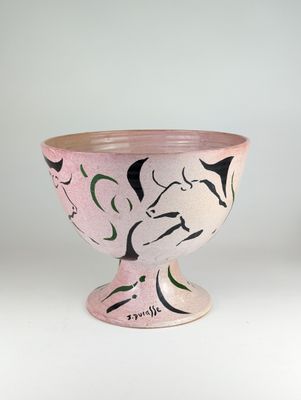 un bol rose orné de motifs noirs et blancs
