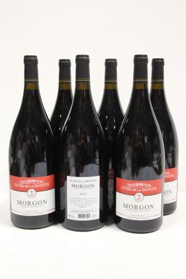 six bottles of red wine are lined up on a white surface