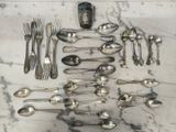 de nombreuses cuillères et fourchettes disposées sur une table en marbre