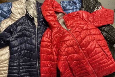 Plusieurs vestes sont alignées sur un portemanteau dans un magasin