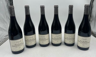six bouteilles de vin sont alignées sur une table
