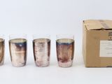 six shot glasses are lined up next to a cardboard box