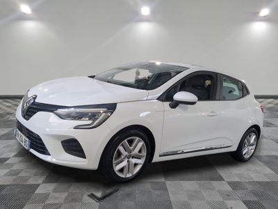 une voiture blanche est garée dans une pièce au sol à carreaux