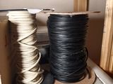 two spools of black and white rope on a shelf