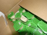 a cardboard box with a bunch of green items inside of it
