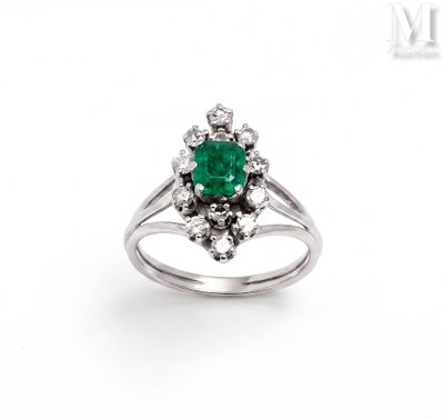 a close up of a ring with a green stone surrounded by diamonds