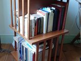 une bibliothèque en bois sur laquelle sont posés des livres et surmontée d'une tête de cheval