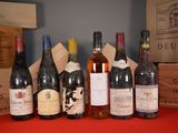 several bottles of wine are lined up on a red table