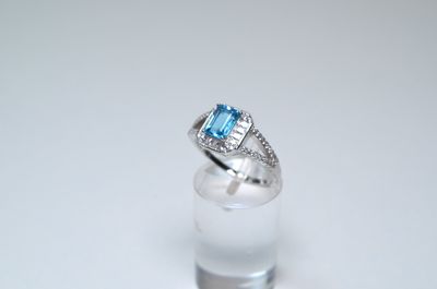 an image of a diamond and blue topaz ring on a clear glass