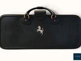 sur la poignée de la valise noire, on voit un cheval