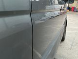 a silver van parked in a parking lot with other vehicles