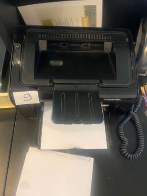 une imprimante posée sur un bureau, à côté d'un téléphone