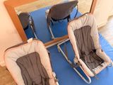 two baby chairs sitting on a blue mat in front of a mirror