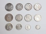 a lot of coins that are on a white surface