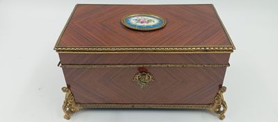 une boîte ancienne en bois ornée d'un médaillon bleu et or sur le couvercle