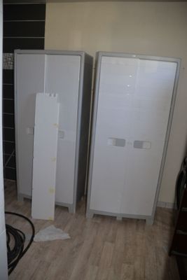 three white refrigerators in a room with a hard wood floor