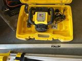une image représentant une boîte à outils jaune contenant un trépied et un laser
