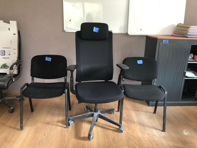 three black office chairs in a room with a white board on the wall