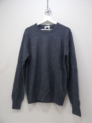 the sweater is hanging on a hanger on the wall