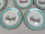 four plates with a picture of a horse drawn carriage on them