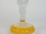 yellow glass vase with an angel head on top on a white surface