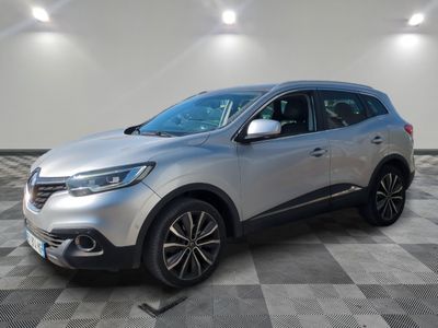 un SUV argenté garé sur un sol en damier dans un garage