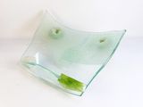 a glass bowl with a green leaf inside of it