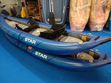 un kayak bleu posé sur un sol bleu dans une pièce