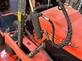 a red lawn mower sitting on the ground in a garage