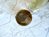 a bottle of liquid and a glass of liquid on a marble table