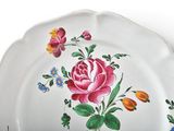a white plate with a pink rose and blue flowers on it