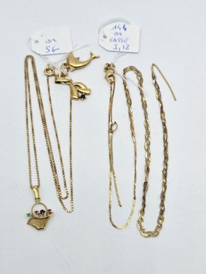 un ensemble de colliers et de bracelets en or posés sur une surface blanche