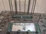 un petit miroir posé par terre à côté d'un porte-vêtements en métal